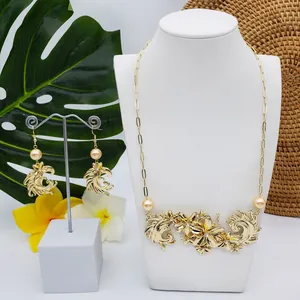 Détail du collier floral doré et des boucles d'oreilles avec perles et strass