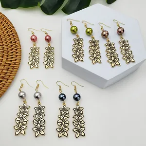 Détail de boucles d'oreilles fleurs dorées vintage avec perles de nacre colorées
