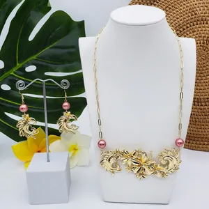 Détail du parure de bijoux dorés avec perles roses et cristaux sur un présentoir à bijoux