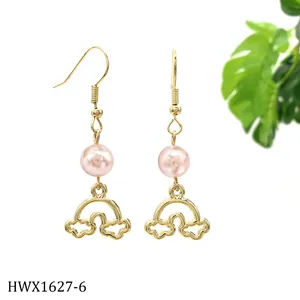 Detail von goldenen Ohrhängern mit rosa Perlen und hohlem Regenbogen-Anhänger-Design