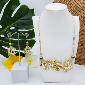 Détails de la parure fleur tropicale dorée avec perles vert olive et gravures florales