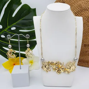 Détail de parure florale dorée avec perles grises et strass brillants sur présentoir