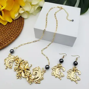 Détail de parure florale dorée avec perles grises présentée sur un support blanc