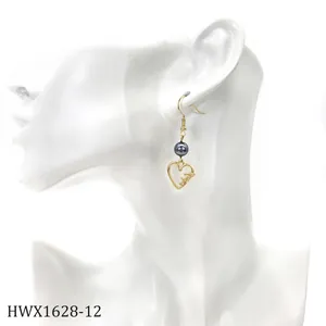 Detailansicht goldener Herz-Ohrhänger mit grauer Perle und Love-Schriftzug Design