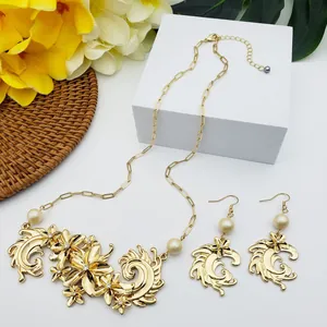 Détail de parure bijoux fleurs vintage dorées avec perles et strass sur socle