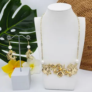 Détail d'un ensemble collier et boucles d'oreilles fleuris dorés avec perles
