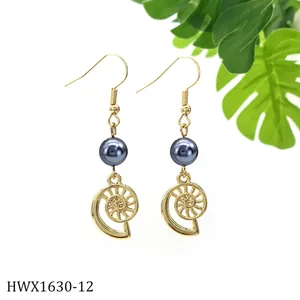 Nahaufnahme goldener Spiralmuschel-Ohrringe mit grauer Perle und Nautilusschale-Muster