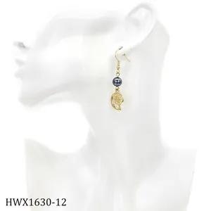 Nahaufnahme von goldenem Muschelohrring mit grauer Perle am Model für Minimalismus