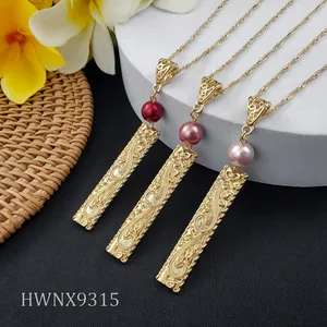 Detailed close-up of Hawaiian style gold pendant necklaces with pearls and floral engravings