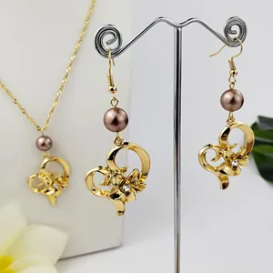 Dettaglio del set gioielli hawaiano in oro con cuori, fiori, perle e piccoli cristalli