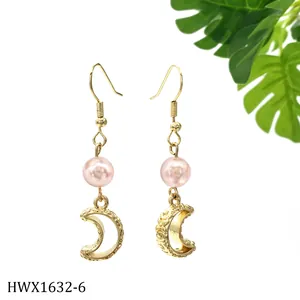 Detail von goldenem Mond-Ohrring mit rosa Perle und feiner Vintage-Gravur im Design