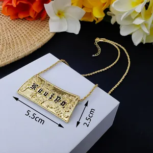 Collier barre Samoa doré avec lettrage Kuuipo noir et chaîne corde sur bloc blanc chic