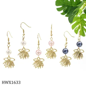 Detailliertes Set aus drei goldenen Ohrringen mit weißen, rosa und grauen Perlenanhängern