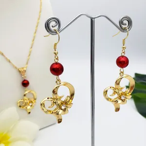 Set gioielli hawaiani in oro con cuore e fiori, perle rosse e dettagli in zircone