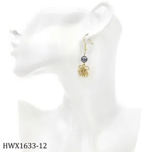 Detail eines goldenen Schleifen-Ohrrings mit dunkelgrauer Perle auf weißem Modell