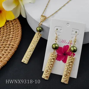 Detailed close-up of Hawaiian style floral embossed gold pendants with dark green pearls