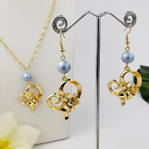 Dettaglio di parure dorata con cuore, perle blu e cristalli per uno stile elegante
