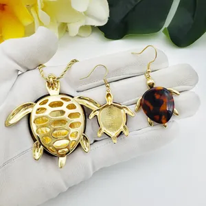 Makroaufnahme von vergoldeter Schildkröten-Halskette und Schildpatt-Ohrringen im Schmuckset