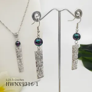 Hawaiian plumeria jewelry set with engraved rectangular pendants and iridescent pearls