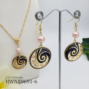 Detailed view of island style jewelry set with black enamel waves and pink pearls