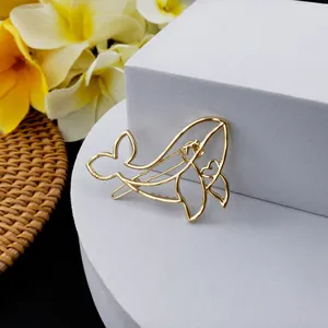Pince à cheveux baleine dorée évidée avec motif cœur sur support de présentation blanc