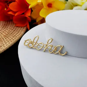 Vue macro détaillée de la broche dorée Aloha avec une texture métallique polie