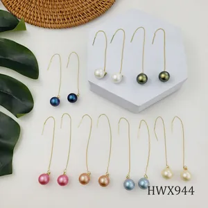 Collezione di orecchini lunghi con perle in sette colori su un espositore minimalista