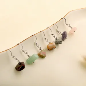 Macro detail of natural crystal drop earrings set on a ceramic dish with silver hooks