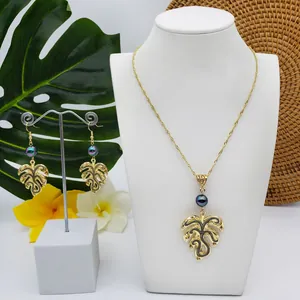 Detail of Monstera leaf jewelry set with dark pearls and tropical background