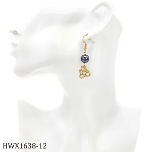 Detail eines Goldohrrings mit dunkelgrauer Perle und Herzanhänger an einem Modell präsentiert