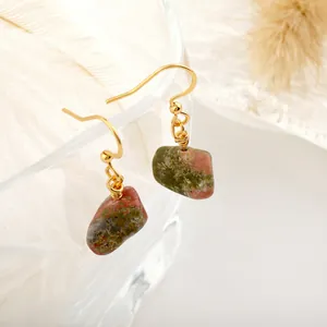 Detail of handmade natural stone earrings with gold hooks and green unakite crystal texture