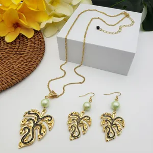 Tropical monstera leaf jewelry set with gold pendant, green pearl and matching earrings