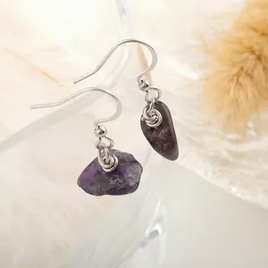 Close-up of handmade raw amethyst crystal earrings with stainless steel hooks and wire wrap