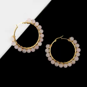 Detail of pink crystal beads hand-wrapped on large gold hoop earrings for women