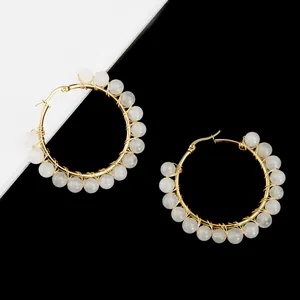 Detailed wire-wrapped gold hoop earrings featuring elegant white translucent beads