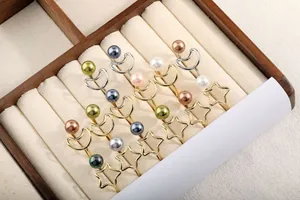 Detail von minimalistischen Stern- und Mondringen mit bunten Muschelperlen in einer Box