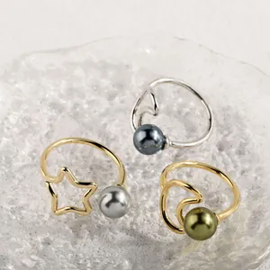 Detailansicht von drei minimalistischen Ringen mit Naturperlen auf einem Glastablett