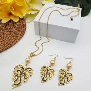 Detail view of Monstera leaf jewelry set with champagne pearls and gold finish