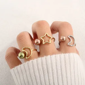 Nahaufnahme der minimalistischen Stern- und Mondringe mit Muschelperlen am Modell