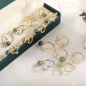 Minimalistische Stern und Mond Ringe mit bunten Perlen auf grünem Samtkästchen