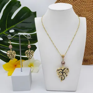 Detail of tropical monstera leaf jewelry set with purple pearls on elegant white stands