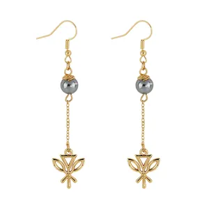 Detail of gold leaf drop earrings with grey pearl beads and geometric hollowed charms