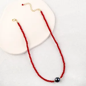 Detail of red crystal beaded necklace with black shell pearl and gold lobster clasp