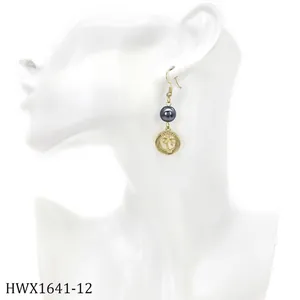 Detailansicht goldener Ohrhänger mit Palmenmotiv, Hawaii-Schriftzug und grauer Perle