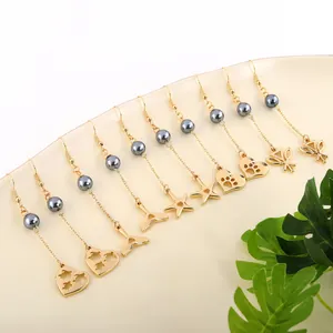 Macro shot of assorted gold hollow earrings with dark grey pearls on a white tray