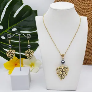 Macro shot of tropical monstera leaf jewelry set with grey pearls on display