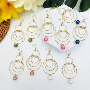 Dettaglio di set di 9 paia di orecchini a cerchio dorati con perle colorate e ganci