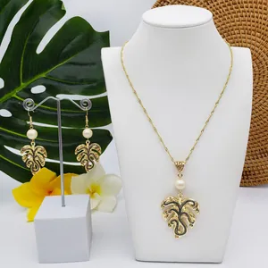 Tropical monstera leaf jewelry set with gold plating and white pearls on a model
