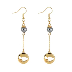 Detailed view of turtle leaf drop earrings with grey pearl beads and hollow metal map charm