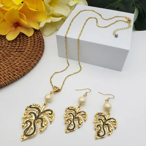 Detail of Monstera leaf jewelry set with white pearls and gold chain on aesthetic decor